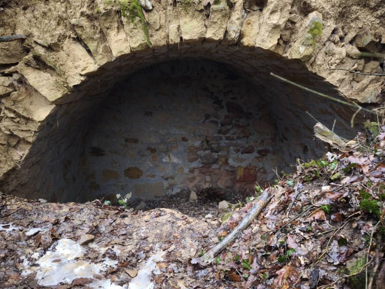 Erdő közepén egy földbe vájt, boltíves építmény