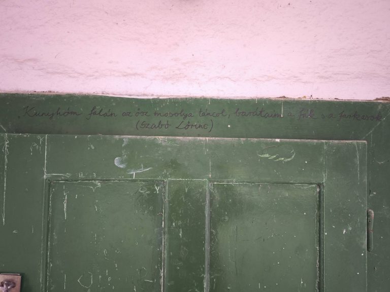 Részlet Szabó Lőrinc Magány című verséből a kulcsosház ajtaján: "Kunyhóm falán az ősz mosolya táncol, barátaim a fák s a farkasok"